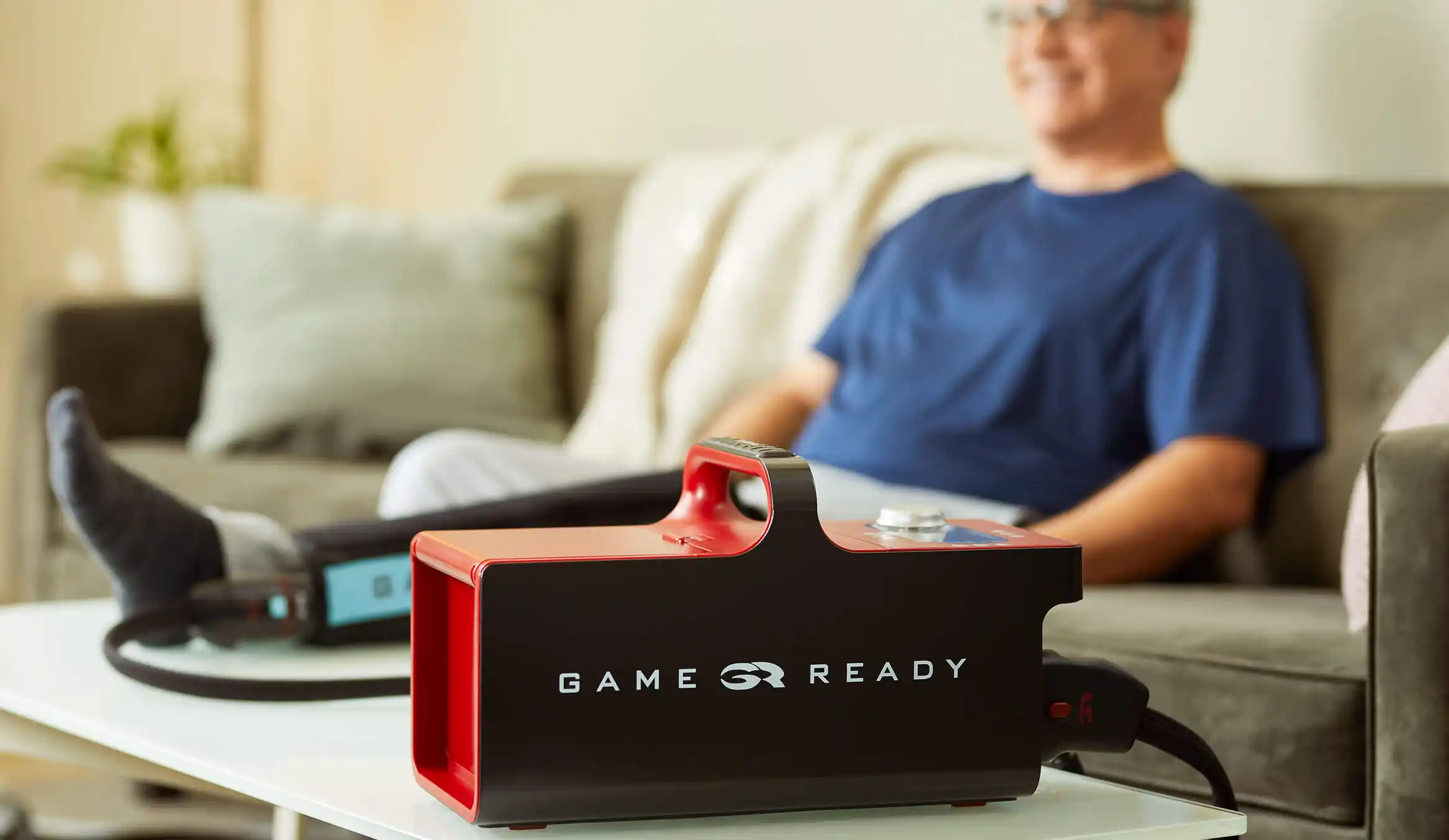 GameReady GRPro 2.1 冷凍加壓主機在家中梳化旁使用,冰水主機透過喉管連接貼身套筒,套於患者下肢作術後消腫